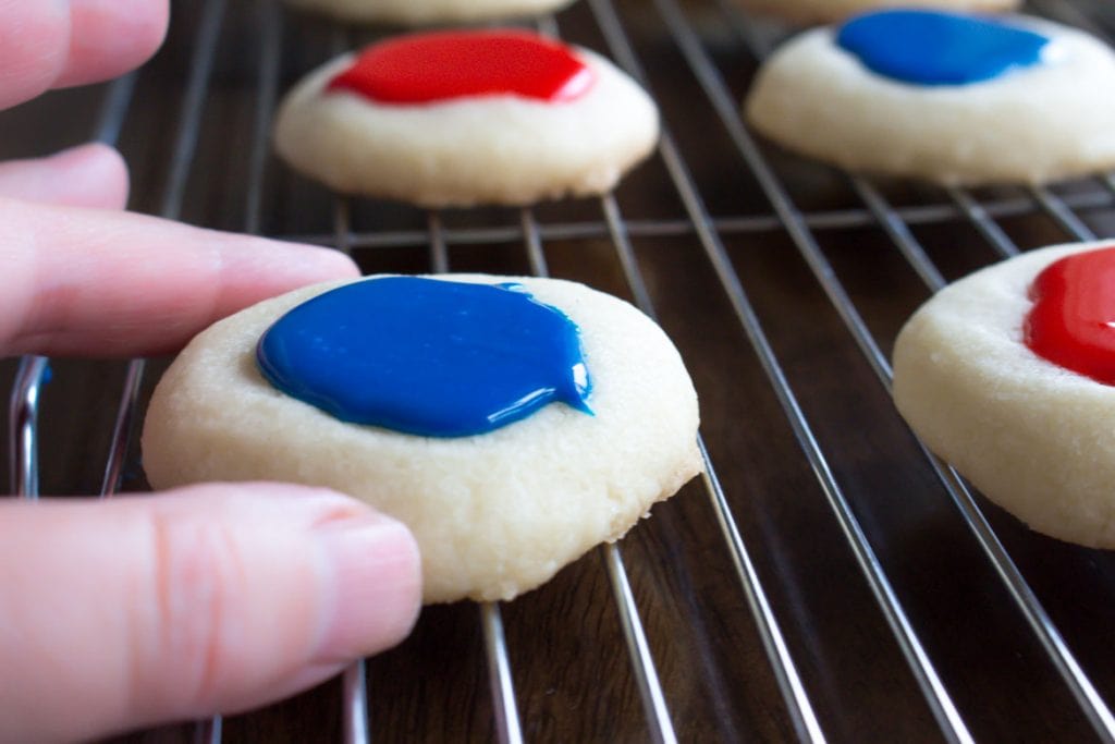 hand holding thumbprint cookies with icing