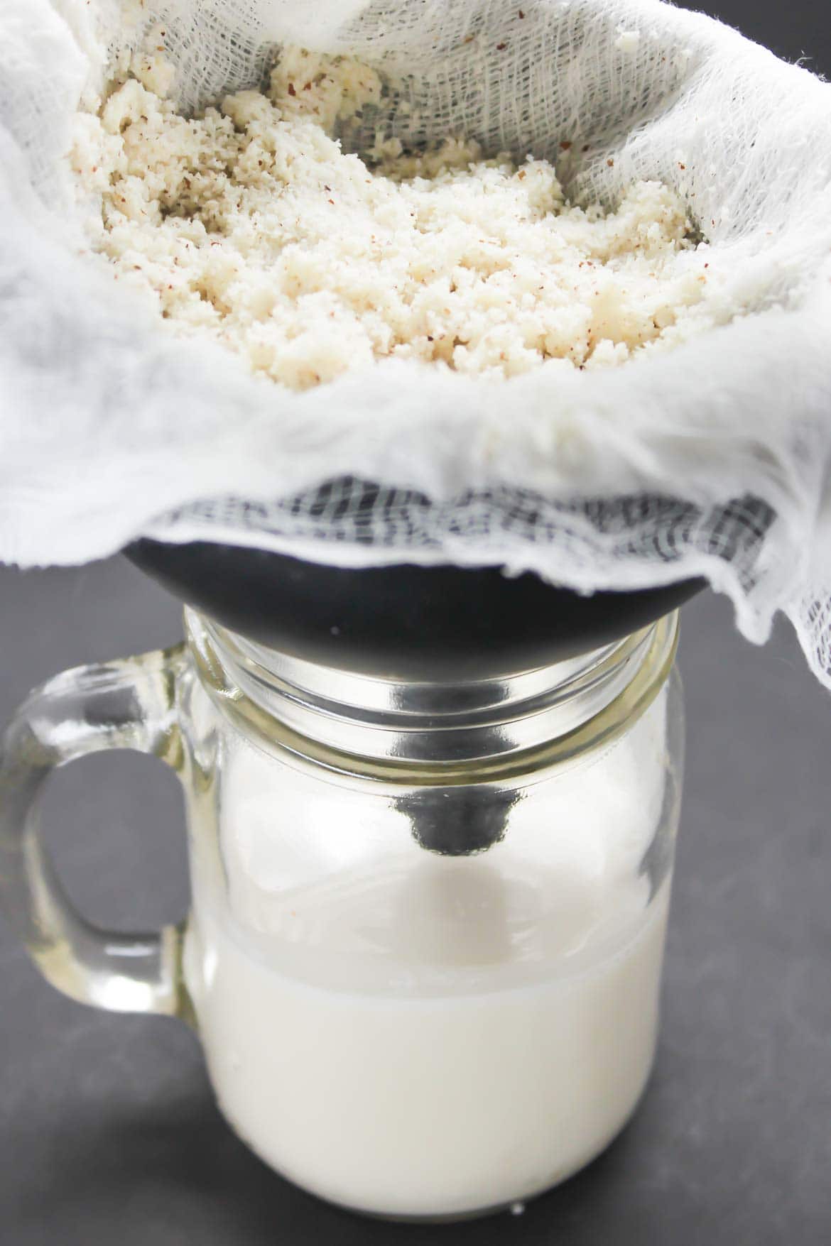 straining Brazil Nut Milk with a cheesecloth