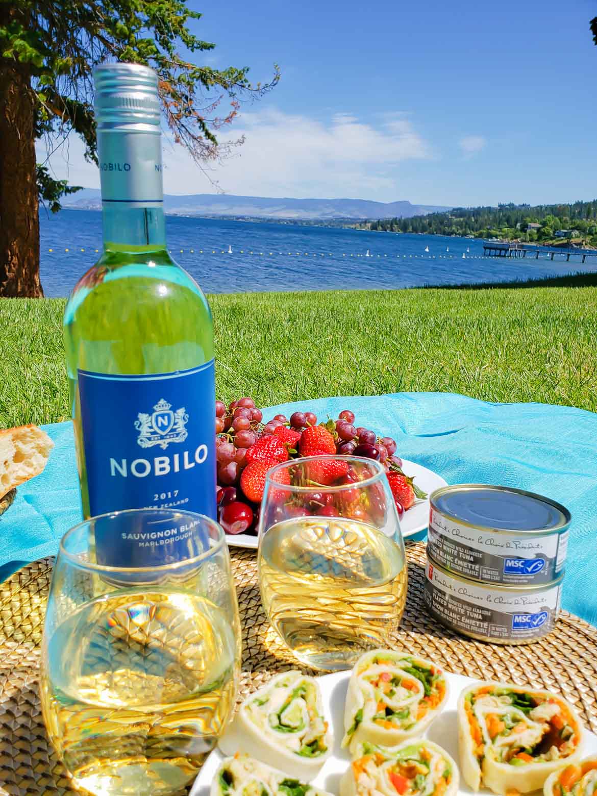 picnic overlooking a lake with Nobilo Sauvignon Blanc wine and pinwheels with MSC certified tuna and fresh veggies 