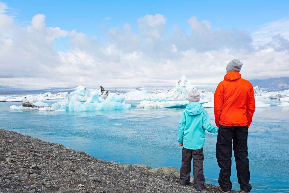 why you need to take and Iceland family vacation - father and child looking at icebergs in jokulsarlon lagoon in Iceland 