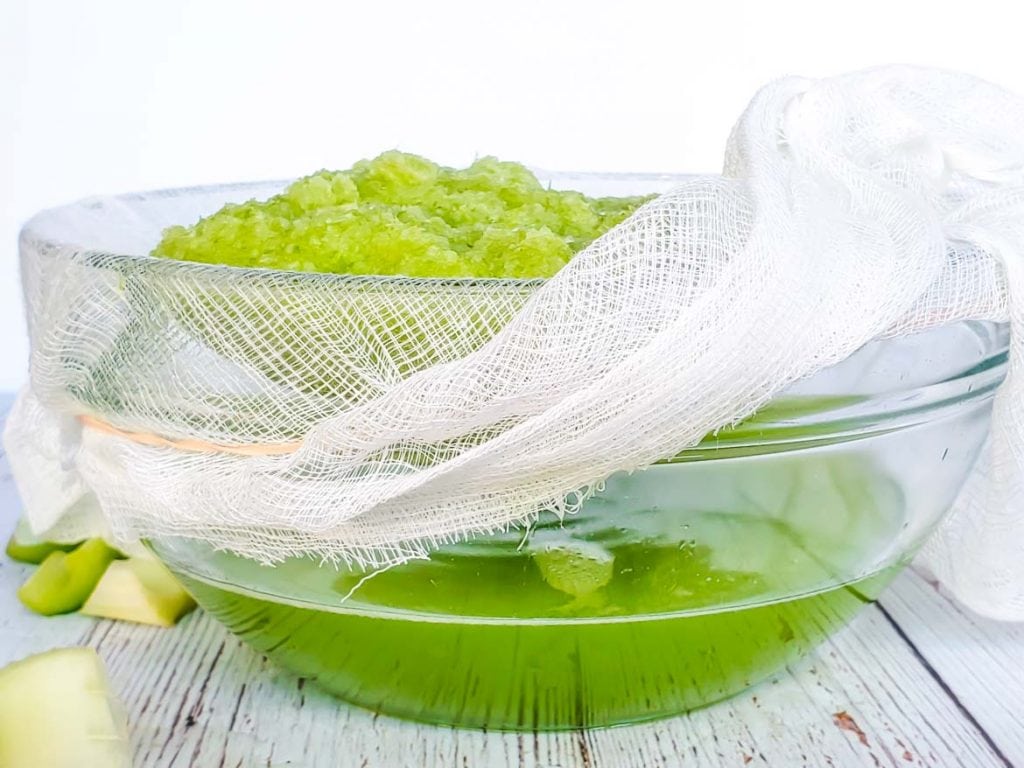 straining celery juice with a cheesecloth