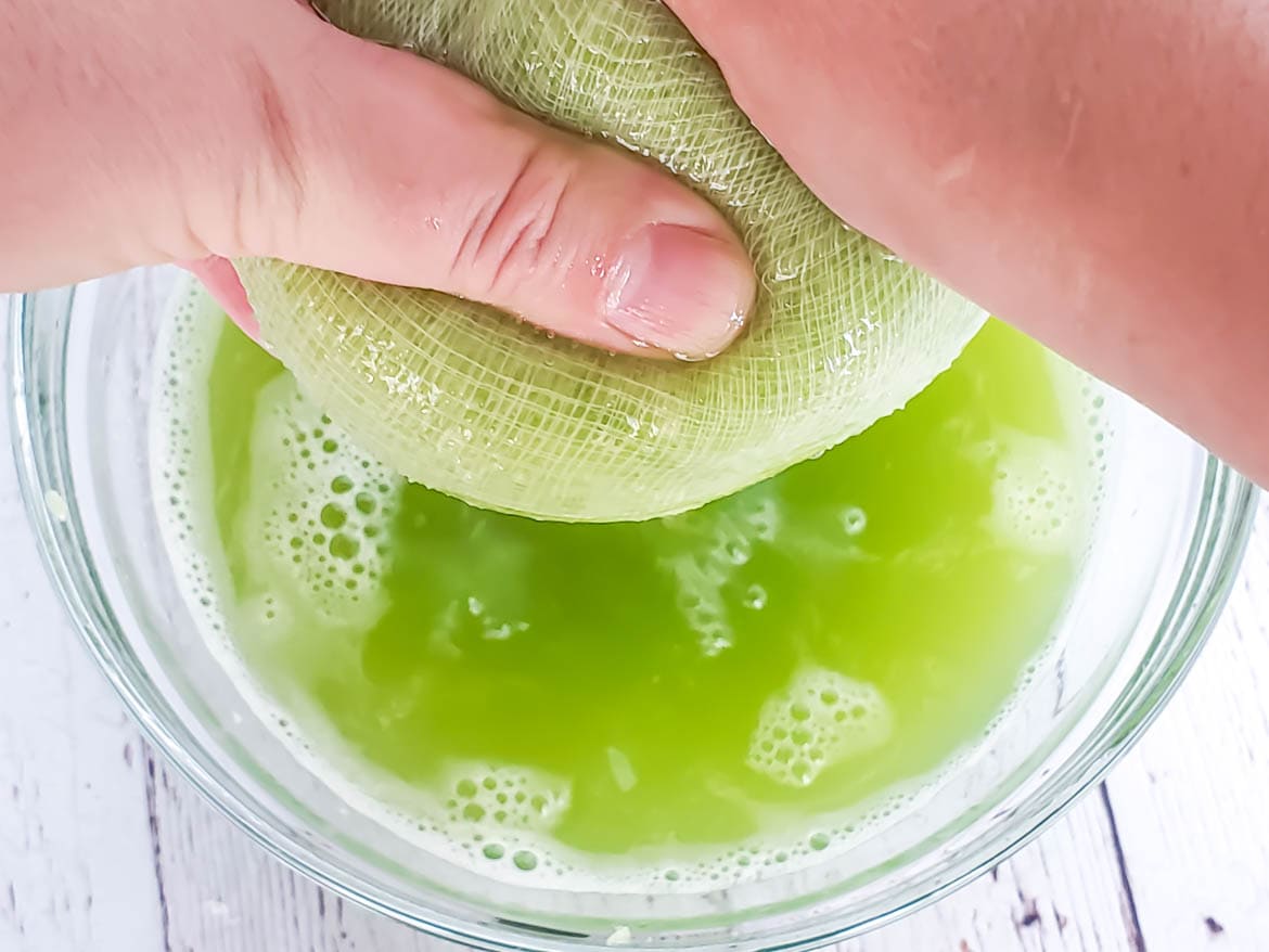 squeezing juiced celery in a cheesecloth - a  juicer blender combo would be easier!