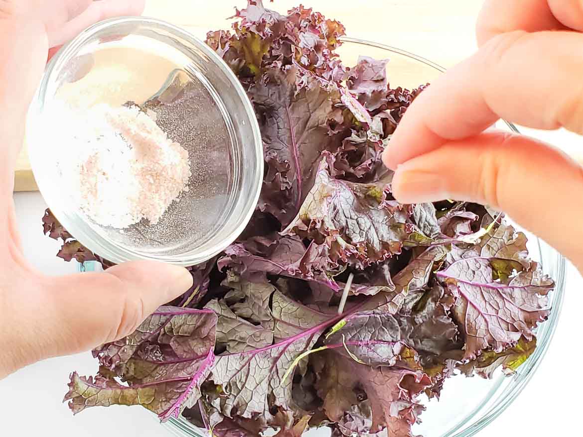 sprinkling purple kale chips with salt before baking