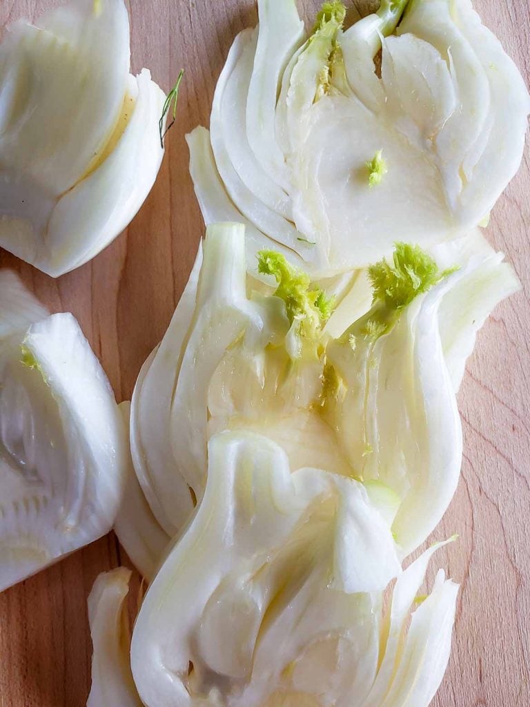 fennel cut into slices on a wooden cutting board