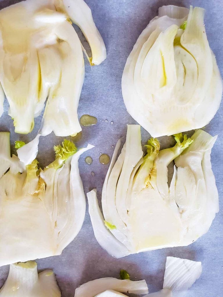 fennel bulb slices on a pan drizzled with olive oil