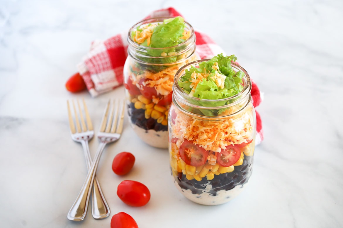 southwest mason jar salad with corn black beans and cheddar cheese