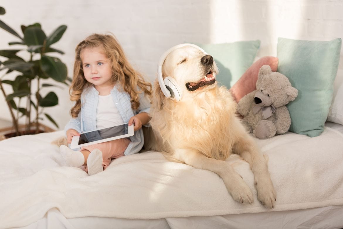 Little girl and dog wearing headphones 