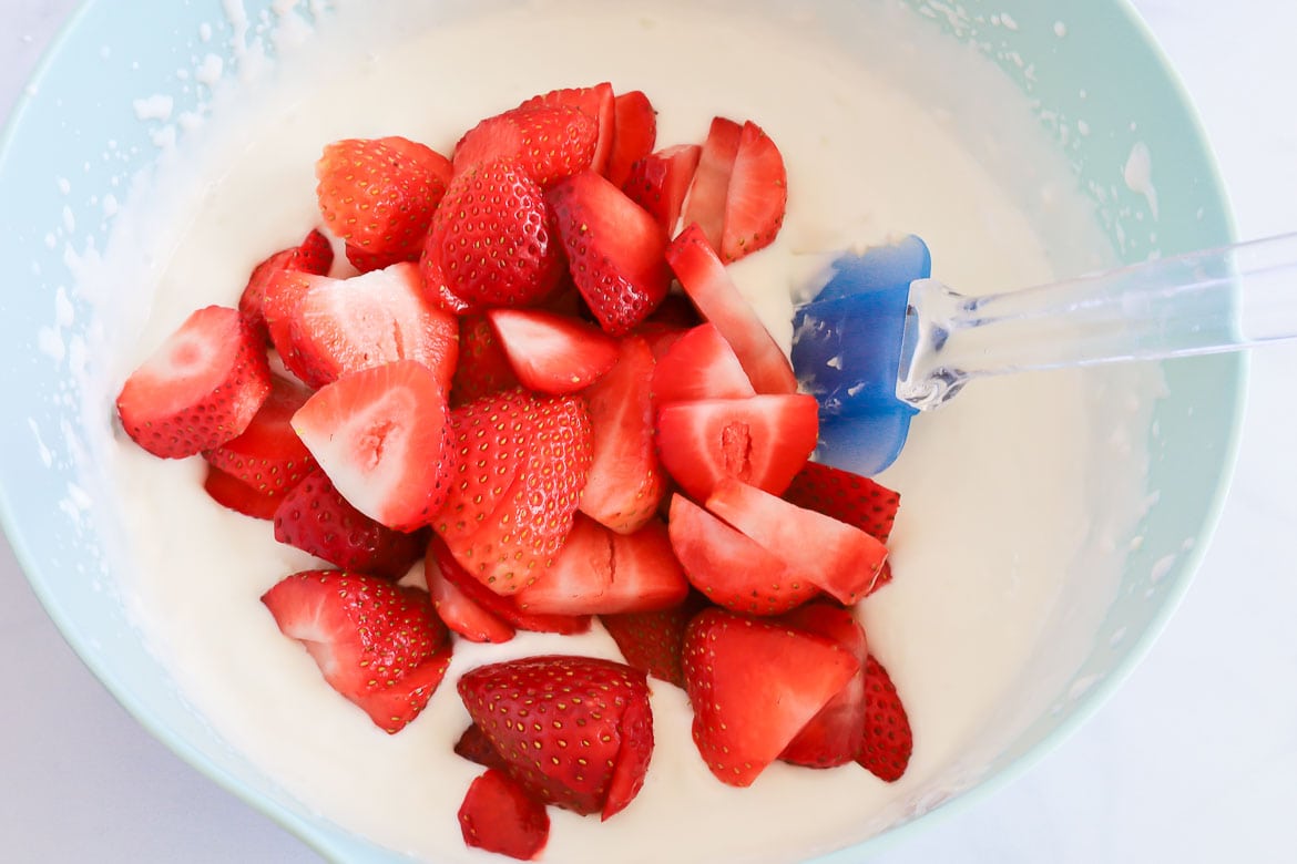 Mixing strawberries into berry cheesecake pops