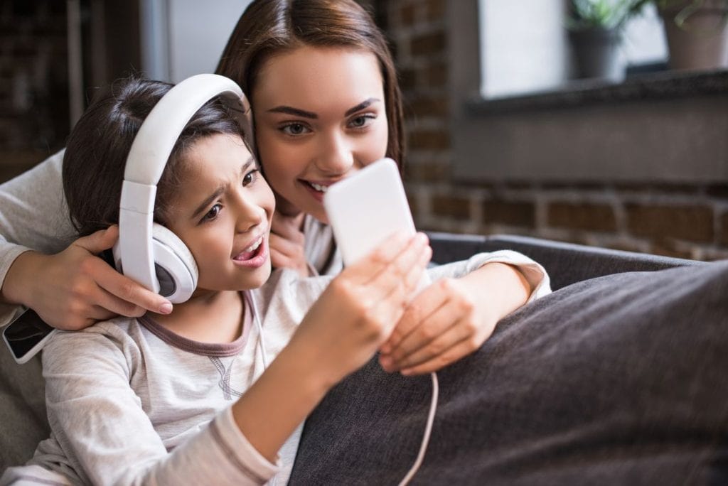 Woman and girl wearing headphones