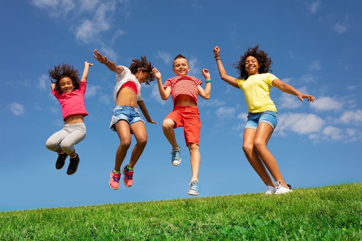 children jumping in the air outside