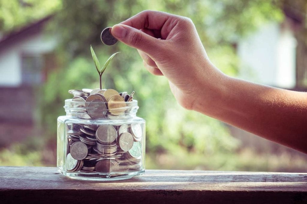 money with seed sprouting in a glass jar