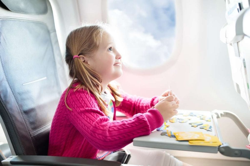 Is Your Child Traveling Alone This Holiday girl in airplane seat