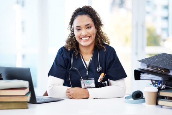 Nurse with books and laptop smiling