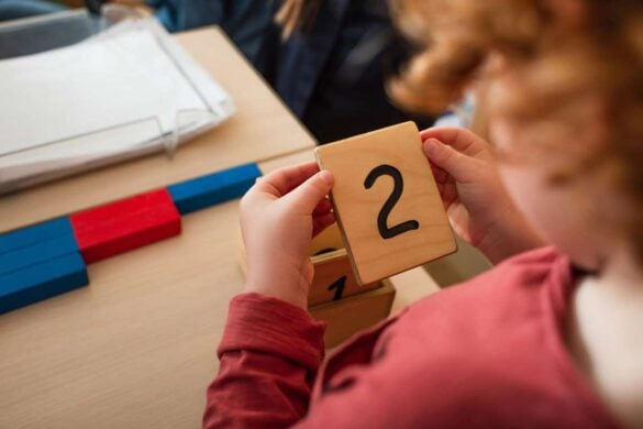 Kindergartener learning math with wooden tile game