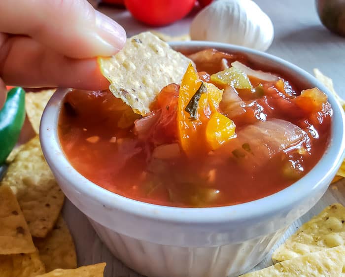 dipping chip in chunky salsa recipe for canning in white bowl