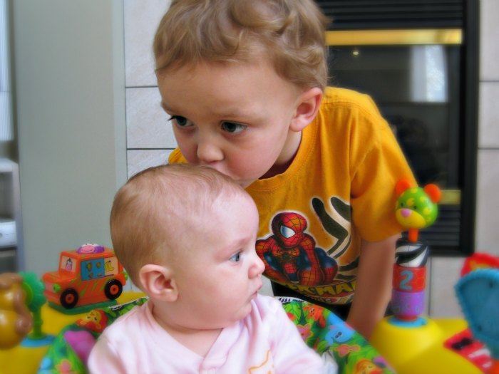 Brother kissing baby sister