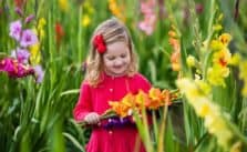 Growing An Edible Flower Garden For Kids child holding gladiolus flowers